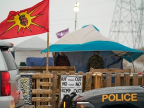 In this file photo taken on February 26, 2020 Ontario Provincial Police and First Nations protestors sit on opposite sides of a barricade on Highway 6 near Caledonia, Ontario which the protestors set up, in support of the Wet'suwet'en hereditary chiefs and the Tyendinaga  Mohawks.