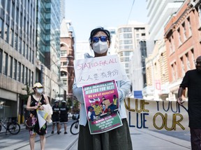 Protestors attend an action in support of migrant worker rights in front of the Immigration and Refugee Board of Canada, in Toronto, on Sunday, Aug., 23, 2020.