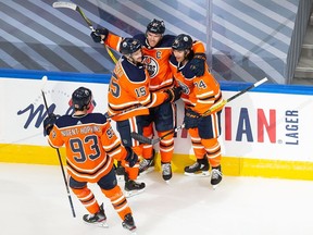 Edmonton Oilers' Ryan Nugent-Hopkins (93), Josh Archibald (15), Connor McDavid (97) and Ethan Bear (74) celebrate a goal during first period NHL Stanley Cup qualifying round action against the Chicago Blackhawks, in Edmonton, Monday, Aug. 3, 2020.