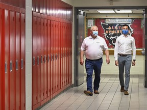 Ontario Premier Doug Ford, left, and Education Minister Stephen Lecce walk the hallway before making an announcement regarding the government's plan for a safe reopening of schools in the fall due to the COVID-19 pandemic at Father Leo J Austin Catholic Secondary School in Whitby, Ont., on Thursday, July 30, 2020.