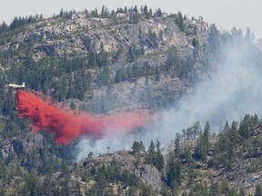 A air tanker drops fire retardant on the Christie Mountain wildfire along Skaha Lake in Penticton, B.C. Thursday, August 20, 2020. Wildfires in the area have forced several thousand people to be on evacuation alert. Wind gusts fanned the flames of a wildfire near a village at the southern end of Columbia Lake in British Columbia late on Saturday increasing the size of the blaze by about four square kilometres.