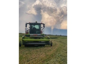 A funnel cloud is seen in the distance of a farmer's field near Virden, Man., in a Friday, Aug. 7, 2020, handout photo.