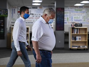 Ontario Premier Doug Ford, right, and Education Minister Stephen Lecce prepare for an announcement at Father Leo J. Austin Catholic Secondary School in Whitby, Ont., Thursday, July 30, 2020. The Ontario government is asking the province's school boards to try to spend $50 million to upgrade air quality in schools by Thanksgiving.