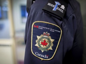 COVID-19 outbreaks in Canada's federal prisons have been declared over, and staff and visitors are preparing for 'a new normal' that could be in place for years. Patches are seen on the arm and shoulder of a corrections officer in the segregation unit at the Fraser Valley Institution for Women during a media tour, in Abbotsford, B.C., Thursday, Oct. 26, 2017.