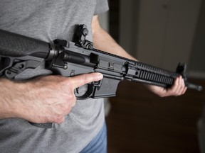 A restricted gun licence holder holds an AR-15 at his home in Langley, B.C., on May 1, 2020.