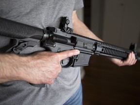 A restricted gun licence holder holds a AR-15 at his home in Langley, B.C., on May 1, 2020.