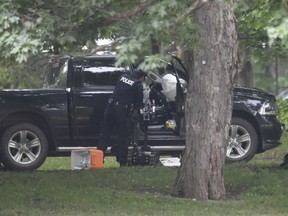 A police examine a pickup truck inside the grounds of Rideau Hall in Ottawa on Thursday, July 2, 2020. The man accused of ramming through a gate at Rideau Hall while heavily armed is slated to return to court Sept. 18 after making a brief appearance Friday.