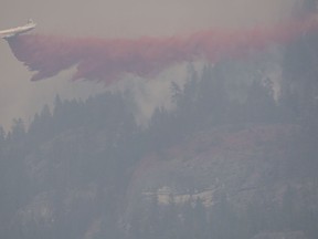 A air tanker drops fire retardant on the Christie Mountain wildfire along Skaha Lake in Penticton, B.C. Wednesday, August 19, 2020. Wildfires in the area have forced several thousand people to be on evacuation alert.