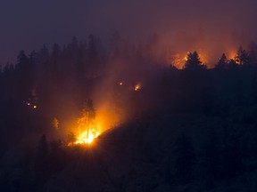Flareups are seen from the Christie Mountain wildfire along Skaha Lake in Penticton, B.C. Thursday, August 20, 2020. An evacuation order for a fire in the southern Interior of British Columbia has been rescinded while other areas are still seeing raging blazes.THE CANADIAN PRESS/Jonathan Hayward