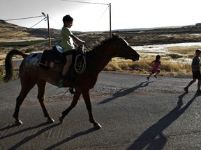 A Jewish settler boy rides a horse as other children play nearby in the Jewish settler outpost of Mitzpe Kramim in the Israeli-occupied West Bank, June 18, 2020.
