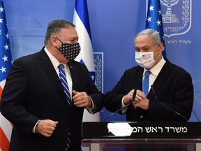 U.S. Secretary of State Mike Pompeo and Israeli Prime Minister Benjamin Netanyahu wearing face masks bump elbows after  a joint news conference in Jerusalem, August 24, 2020.