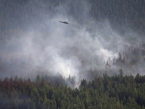 A helicopter dumps a load of water on the Philpot Road fire outside of Kelowna, B.C., Monday, August 28, 2017. Several lightning-caused wildfires were sparked in southern B-C over the long weekend. Although all are less than 25 hectares, one northwest of Princeton has prompted an evacuation alert.