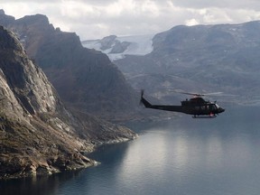 A Canadian military Griffon helicopter flies along the shoreline of Baffin Island as it moves personnel between Operation Nanook and Iqaluit, Tuesday, August 26, 2014. Canada and some of its closest allies are launching a major naval exercise in the Arctic this week that aims to send a message of unity without spreading COVID-19.