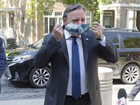 Quebec Premier Francois Legault removes his face mask to speak to the media as he arrives for a visit to a CHSLD seniors residence in L'Assomption, Que., Tuesday, Aug. 11, 2020.THE CANADIAN PRESS/Ryan Remiorz