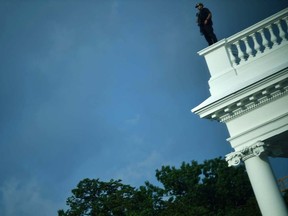 A member of the US Secret Service takes up position on the roof as the White House is locked down in Washington, DC, on August 10, 2020. - Secret Service guards shot a person, who was apparently armed, outside the White House on August 10, 2020. President Donald Trump said just after being briefly evacuated in the middle of a press conference.