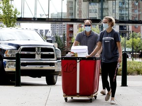 Second year MacEwan University student Devyn Pierog is helped by her father as she moves into residence and prepares to return to classes in September, in Edmonton on Aug. 13, 2020.