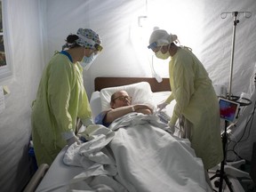 Patient Vince Norris, 65, gets a visit on May 13, 2020, by medical staff at Windsor Regional Hospital's field hospital, set up at St. Clair College's SportsPlex to help the local health system cope during the COVID-19 pandemic.
