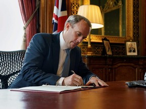 Britain's Foreign Secretary Dominic Raab signs a letter to fellow MPs in the Foreign & Commonwealth Office in London, July 6, 2020, following the launch of new Human Rights Sanctions. Britain had identified 49 individuals and organizations to be sanctioned under a new regime targeting people who violate human rights, 25 of them Russian and 20 Saudis.