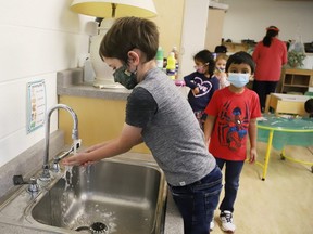 A kindergarten student wears a mask and washes his hands prior to a nutrition break at MacLeod Public School in Sudbury, Ont. on Tuesday September 8, 2020.