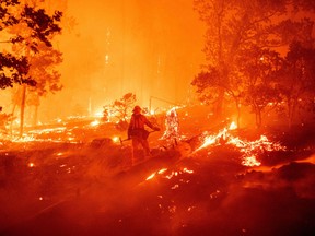 A firefighter works the scene as flames push towards homes during the Creek fire in the Cascadel Woods area of unincorporated Madera County, California on September 7, 2020.