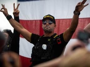 A man in a Fred Perry polo shirt gestures the OK sign that is now seen as a symbol of white supremacy, as hundreds gathered during a Proud Boys rally at Delta Park in Portland, Oregon on September 26, 2020.