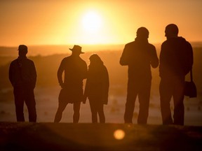 People watch as the sun rises over the Somerset Levels from Glastonbury Tor on the autumn equinox, September 22, 2017 in Somerset, England. The transition from summer to autumn is defined by the autumn equinox, when day and night are of roughly equal length and nights begin to become increasingly longer until spring.