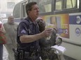 A police officer helps a woman to a bus after she fled the area near the World Trade Center, in New York on Sept. 11, 2001.