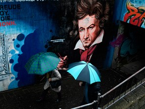 Pedestrians pass a mural depicting German composer Ludwig van Beethoven in his native city of Bonn, western Germany, on Dec. 13, 2019.
