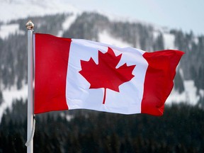 A Canadian flag flies over the Lake Louise ski lodge in Alberta in a file photo from Nov.  29, 2017. The nation needs to espouse serious and useful goals of international reform and accelerate economic growth, writes Conrad Black.