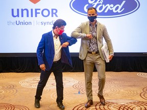 Unifor President Jerry Dias, left, elbow bumps Ryan Kantautas, Vice-President of Human Resources at Ford Canada, in Toronto on Aug. 12, 2020. Unifor workers have ratified a three-year deal with Ford Canada that will result in new electric vehicles being built in Ontario.