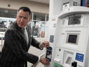 Ontario Energy Minister Greg Rickford applies an anti-carbon tax sticker to a gas pump, April 8, 2019.