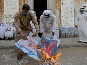 Palestinians burn pictures depicting Israeli Prime Minister Benjamin Netanyahu and U.S. President Donald Trump during a protest against Bahrain's move to normalize relations with Israel, in the central Gaza Strip, on Sept. 12.