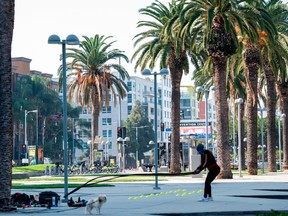 A person wearing a mask works out in front of the Convention Center downtown L.A. on Sept. 18, 2020. (Photo by VALERIE MACON/AFP via Getty Images)