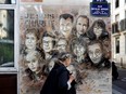A woman walks past a painting by French street artist Christian Guemy, known as C215, in tribute to members of the Charlie Hebdo magazine who were killed by jihadist gunmen in January 2015, in Paris, on Aug. 31, 2020. Fourteen of the gunmen's alleged accomplices are now on trial.