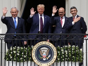 Israeli Prime Minister Benjamin Netanyahu, from left, U.S. President Donald Trump, Bahrain Foreign Affairs Minister Abdullatif bin Rashid Al Zayani, and UAE Foreign Affairs Minister Abdullah bin Zayed Al Nahyan wave from a White House balcony after Netanyahu signed a peace deal with the UAE and a declaration of intent to make peace with Bahrain, on Sept. 15, 2020.