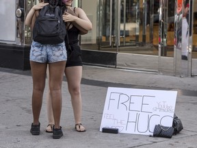 A woman offers “Free Hugs” at the corner of Yonge Street and Dundas Street in Toronto amid the COVID-19 pandemic, Sept. 3, 2020.