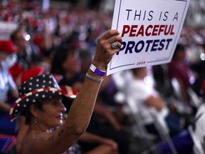 A supporter holds up a sign as U.S. President Donald Trump rallies at a campaign event in Henderson, Nev., on Sept. 13, 2020.