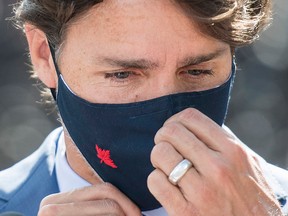 Prime Minister Justin Trudeau adjusts his face mask following a news conference in Montreal on Aug 31, 2020.