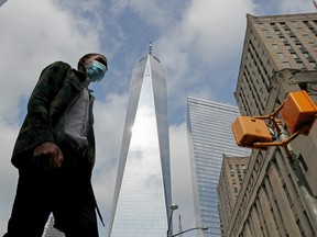 A man wearing a protective face mask walks by One World Trade Center two days before the 19th anniversary of the 9/11 attacks in the lower section Manhattan, New York City, U.S., September 9, 2020.