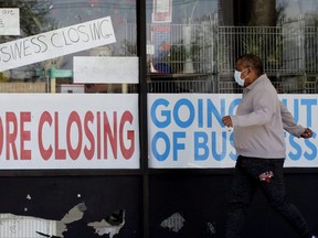 A man looks at signs of a closed store due to COVID-19 in Niles, Illinois, May 21, 2020.  U.S. businesses shed 2.76 million jobs in May due to the economic damage caused by the coronavirus pandemic. The payroll company ADP reported in May that businesses had let go of a combined 22.6 million jobs since March.