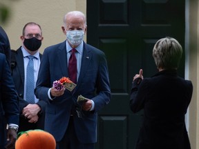 Democratic presidential nominee and former Vice President Joe Biden buys a flower decoration from a woman in front of the  St. Joseph On the Brandywine church in Wilmington, Delaware after attending a morning service on September 27, 2020.