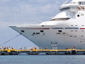 Passengers of the Carnival Sensation, operated by Carnival Cruise Line, are seen next to the docked cruise ship in Cozumel, Mexico June 6, 2019.