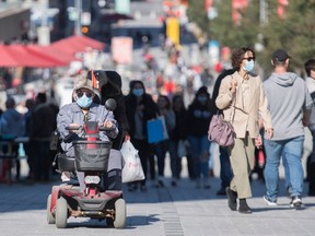 People wear face masks on a street in Montreal, Sunday, Sept. 20, 2020, as the COVID-19 pandemic continues in Canada and around the world.