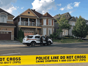 York Regional police officers stand outside of a Markham, Ont., home after four bodies were found, July 28, 2019.