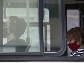 People wear face masks as they sit on a bus in Montreal, Saturday, Sept. 5, 2020, as the COVID-19 pandemic continues in Canada and around the world.