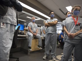 Dr. Del Dorscheid, centre, takes part in board rounds in the COVID-19 intensive care unit at St. Paul's hospital in downtown Vancouver on April 21, 2020. Canadians appear to still have solid faith in doctors and scientists nearly six months into the COVID-19 pandemic. A new survey done for Proof Strategies over the Labour Day weekend suggests more than eight in 10 Canadians trust doctors and almost eight in 10 trust scientists.