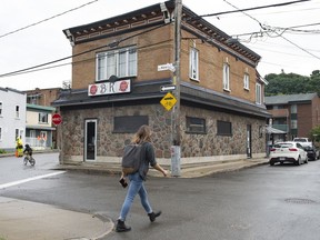 A man walks by the Bar Kirouac which was closed after people that were infected by the COVID-19 participated in a karaoke in Quebec City on September 2, 2020. The head of a Quebec bar owners' association says the provincial government is banning karaoke indefinitely due to concerns over COVID-19. Renaud Poulin of the Corporation des proprietaires de bars, brasseries et tavernes du Quebec says he was informed of the measure by the provincial Health Department Thursday.