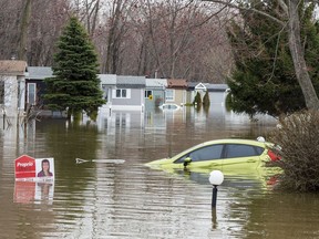 A car sits submerged in floodwater on Wednesday, May 1, 2019 in Ste-Marthe-sur-la-Lac, Que. A city northwest of Montreal has announced that its insurance company is suing the maker of a dike that burst during last year's spring floods, forcing the evacuation of thousands of residents.