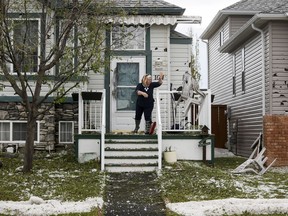 Dee Manning throws hail damaged chairs from the porch of her parents house as residents begin cleaning up in Calgary on Sunday, June 14, 2020, after a major hail storm damaged homes and flooded streets on Saturday. A series of severe weather events in Alberta this year has led to insured damage above the 10 year average for all of Canada.
