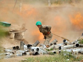 A serviceman of Karabakh's Defence Army fires an artillery piece towards Azeri positions during fighting over the breakaway Nagorny Karabakh region on September 28, 2020.